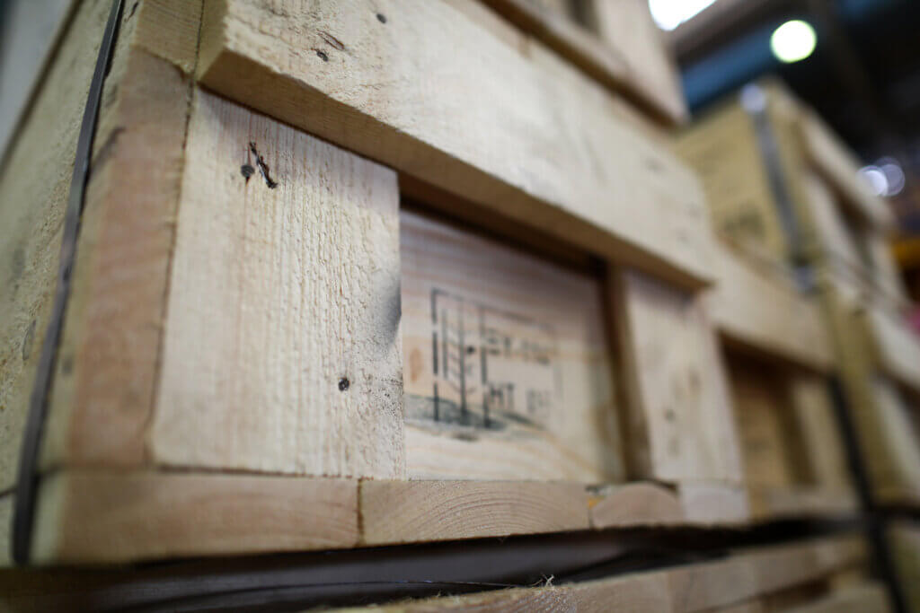 Stack of old wooden packaging boxes standing in column order close-up.